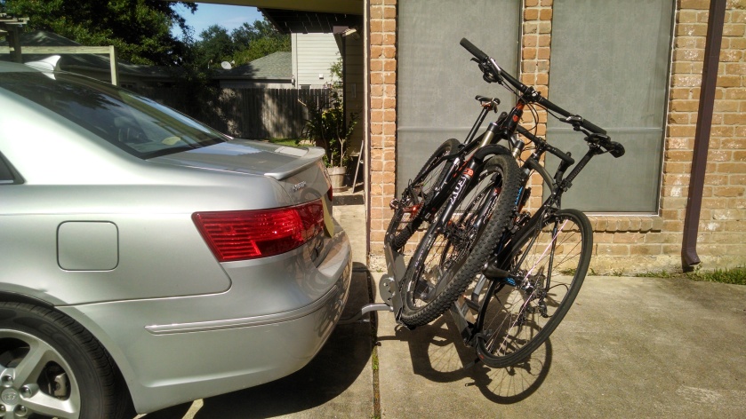 Bikes loaded, rack tilted for trunk access.